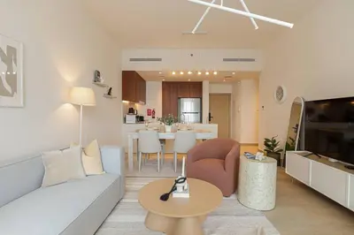 a living room with a couch and a table at HiGuests - Dream stay in our Cozy 2BR in La Rive Community in Dubai