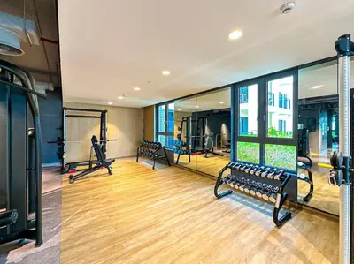 a gym with treadmills and benches in a room at HiGuests - Dream Vacation Apartment in La Rive 1 in Dubai