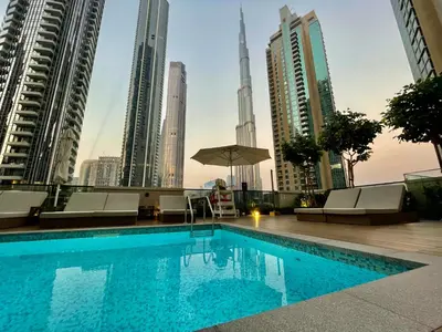 a swimming pool in the middle of a city with tall buildings at Chic Lux 2BR I High Floor l by Burj Khalifa & Dubai Mall I Pool l Gym in Dubai