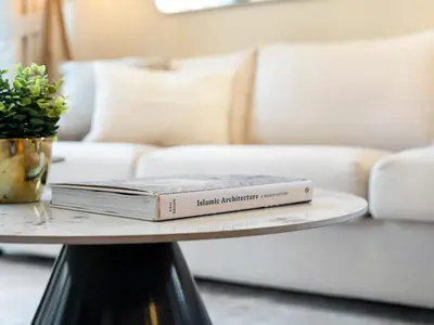 a book on a coffee table with a couch at Luxurious & Spacious 2BR l Burj & Fountain Views l Walk to Dubai Mall l Pool l Gym in Dubai
