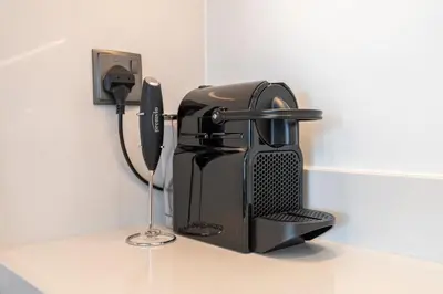 a coffee maker sitting on a counter next to a phone at Luxurious & Spacious 2BR l Burj & Fountain Views l Walk to Dubai Mall l Pool l Gym in Dubai
