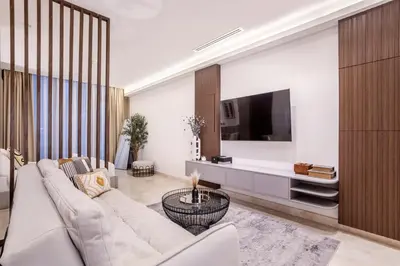 a living room with a white couch and a tv at Stylish Studio Walk to Dubai Mall & Burj Khalifa in Dubai