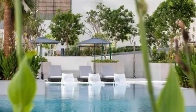 a pool with white chairs and umbrellas at Stylish Studio Walk to Dubai Mall & Burj Khalifa in Dubai
