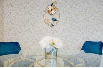 a table with a clock and a vase of flowers at Elegant 2-BR Gem Quick Access Downtown Dubai in Dubai