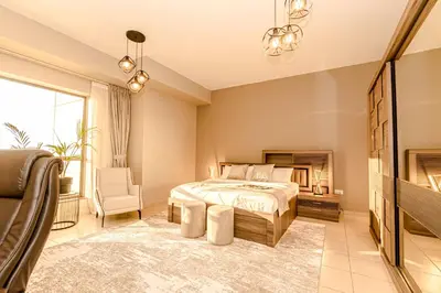 a bedroom with a bed and a chair at GMA Rimal5 4BR Sea View in Dubai