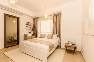 a white bedroom with a large bed and a mirror at GMA Rimal5 4BR Sea View in Dubai