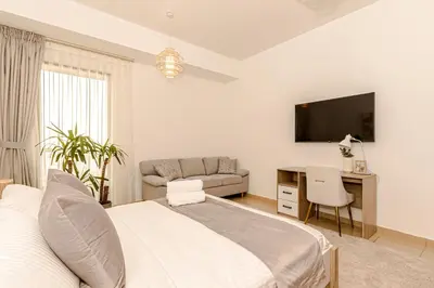 a bedroom with a bed and a desk and a couch at GMA Rimal5 4BR Sea View in Dubai