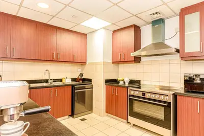 a large kitchen with wooden cabinets and a sink at GMA Rimal5 4BR Sea View in Dubai