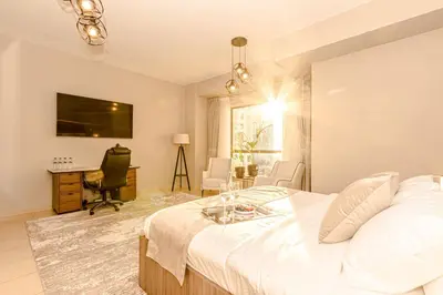 a bedroom with a bed and a desk and a television at GMA Rimal5 4BR Sea View in Dubai
