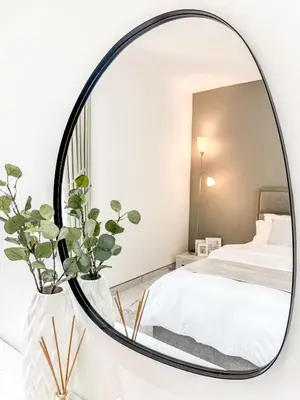a round mirror in a bedroom with a bed at GMA Murjan 2BR Sea View High Floor in Dubai