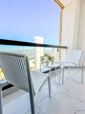 two white chairs and a table on a balcony at GMA Murjan 2BR Sea View High Floor in Dubai