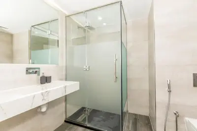 a bathroom with a glass shower and a sink at GMA Murjan 2BR Sea View High Floor in Dubai