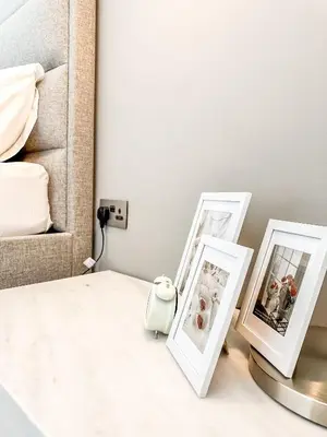 two framed photographs sitting on a table next to a bed at GMA Murjan 2BR Sea View High Floor in Dubai