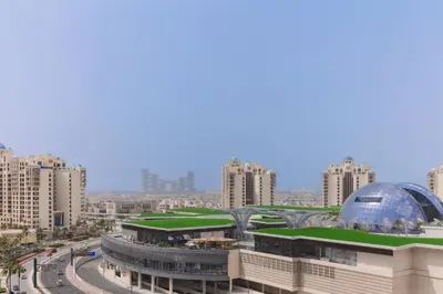 a building with a green roof and a glass dome at Fully-equipped studio Palm Jumeirah, Seven in Dubai