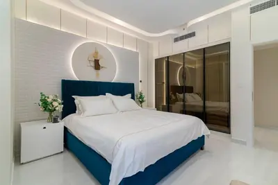 a bedroom with a blue bed and a mirror at USMANS 4BDRM APARTMENT SEA VIEW Direct BEACH Access Fully Serviced JBR in Dubai