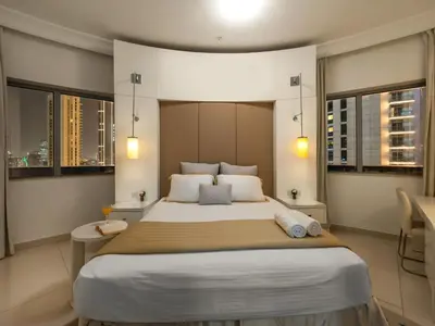 a bedroom with a large bed and two windows at Luxury 1br Burj Khalifa View in Dubai