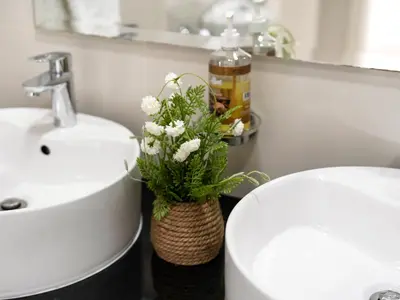 a bathroom with a sink and a vase with flowers at Luxury 1br Burj Khalifa View in Dubai
