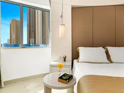 a bedroom with a bed and a table and a window at Luxury 1br Burj Khalifa View in Dubai