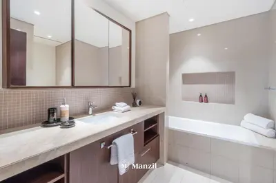 a bathroom with a sink and a tub and a mirror at Manzil - 3BR in Boulevard Point connected to Dubai Mall with Incredible View of Burj Khalifa in Dubai