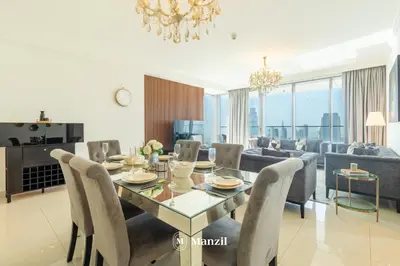 a dining room and living room with a table and chairs at Manzil - 3BR in Boulevard Point connected to Dubai Mall with Incredible View of Burj Khalifa in Dubai