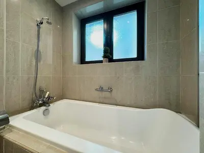 a white bath tub in a bathroom with a window at Golden Homes Souk Al Bahar Burj khalifa view Tajer residences 1BR Mint avenue Near , Dubai mall & burj khalifa in Dubai