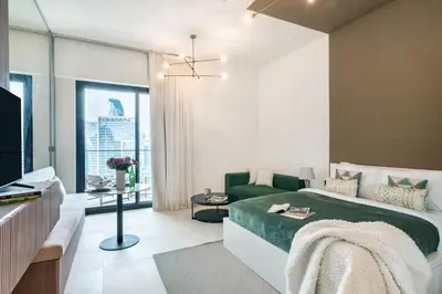 a bedroom with a green bed and a television at The Smart Concierge - Binghatti Canal in Dubai