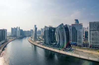 a city with tall buildings next to a river at The Smart Concierge - Binghatti Canal in Dubai