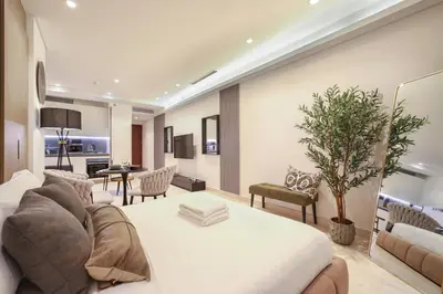 a living room with a large white bed and a living room at Voguish studio! Walk to Burj Khalifasleeps 3! in Dubai