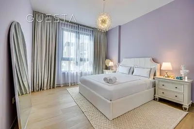 a bedroom with a large white bed and a window at La Voile by Merass, La Mer Dubai in Dubai