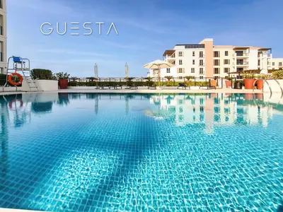a large pool with blue water in front of a building at La Voile by Merass, La Mer Dubai in Dubai