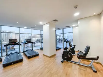 a gym with treadmills and elliptical machines at Frank Porter - Ocean Heights in Dubai