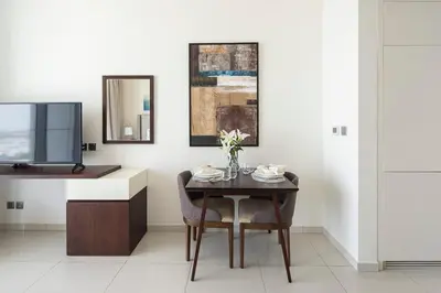 a dining room with a table and a tv at Frank Porter - Avanti Tower in Dubai