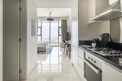 a kitchen with white cabinets and a stove top oven at Frank Porter - Avanti Tower in Dubai