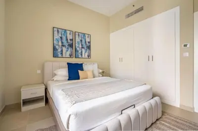 a bedroom with a large white bed with blue pillows at GuestReady - Beachside Escape near Marina Beach in Dubai