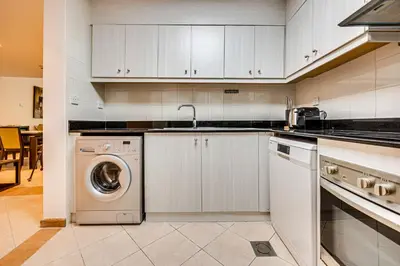 a kitchen with a washing machine and a sink at Stunning 1BD Marina view apartment in Dubai Marina in Dubai