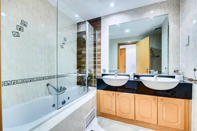 a bathroom with two sinks and a tub and a mirror at Stunning 1BD Marina view apartment in Dubai Marina in Dubai