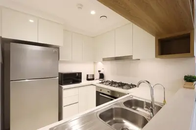 a kitchen with white cabinets and a stainless steel refrigerator at Luxury 3B and maids Burj View, Steps to Dubai Mall in Dubai