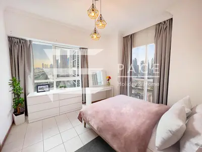 a bedroom with a large window and a bed at 1 Bedroom Apartment in JLT in Dubai