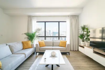 a living room with a couch and a tv at GMA Amwaj 2BR Sea View High Floor in Dubai