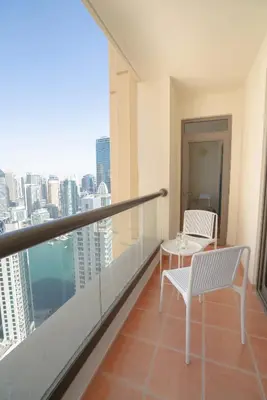 a balcony with a table and chairs and a view of the city at GMA Amwaj 2BR Sea View High Floor in Dubai