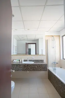 a bathroom with a sink and a tub and a mirror at GMA Amwaj 2BR Sea View High Floor in Dubai