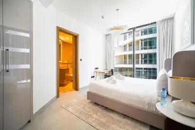 a bedroom with a bed and a large window at SettlerHomes - 2BR Downtown Haven, Ideal For Family Comfort in Dubai