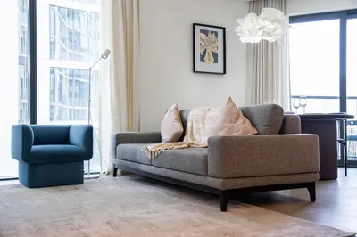 a living room with a couch and a chair at SettlerHomes - 2BR Downtown Haven, Ideal For Family Comfort in Dubai