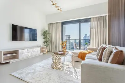 a living room with a couch and a tv at Frank Porter - Act One Act Two T1 in Dubai