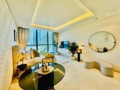 a large living room with a bed and a mirror at Chic Studio with Burj Views at Sterling by Omniyat in Dubai