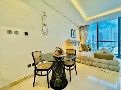 a bedroom with a bed and a table and chairs at Chic Studio with Burj Views at Sterling by Omniyat in Dubai