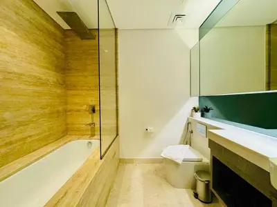 a bathroom with a tub and a toilet and a shower at Chic Studio with Burj Views at Sterling by Omniyat in Dubai