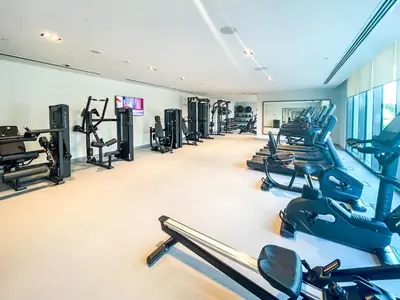 a gym with rows of treadmills and machines at Amazing Apartment with City Views in Downtown 164BC-2 in Dubai