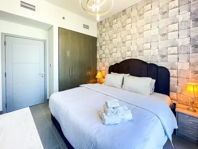 a bedroom with a large white bed with towels on it at Cozy Apartment with City Views Next to Burj Khalifa 166FO1-2 in Dubai