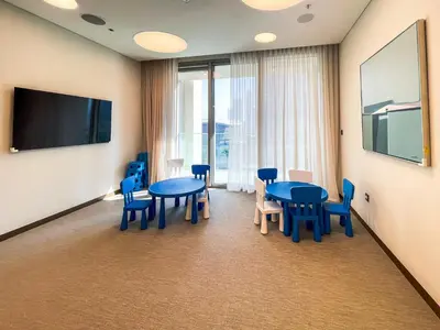 a conference room with blue tables and chairs and a flat screen tv at Cozy Apartment with City Views Next to Burj Khalifa 166FO1-2 in Dubai
